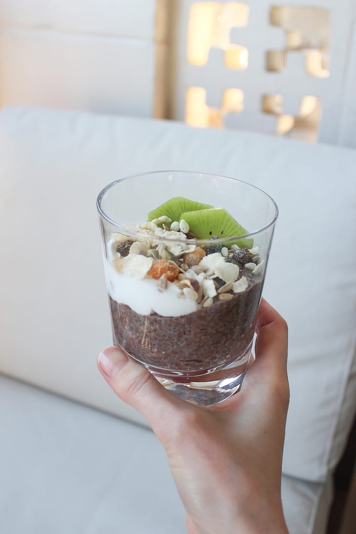 A photo of Chocolate Chia Seed Pudding topped with yoghurt, muesli and kiwi fruit